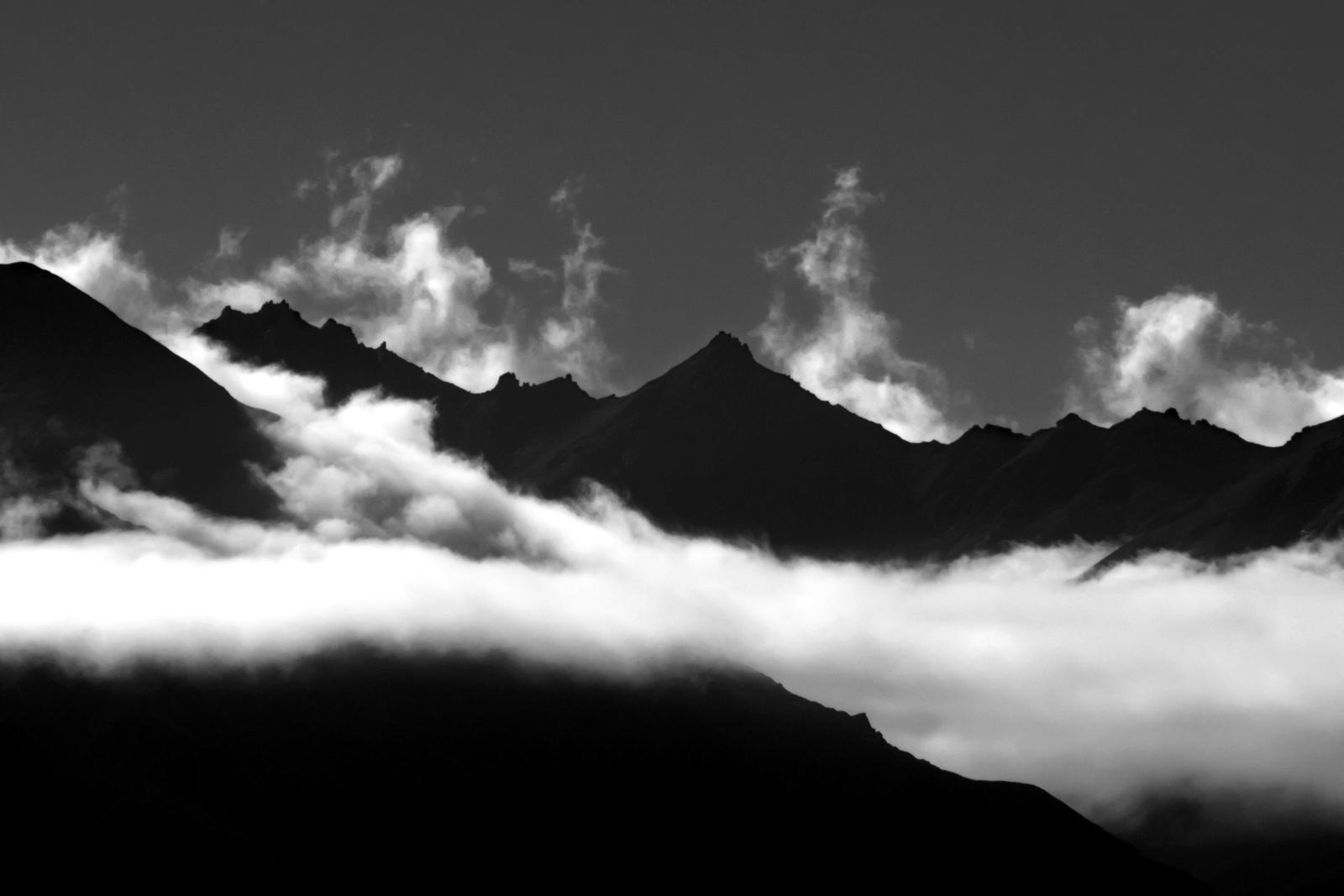 Mountain ridges above a sea of clouds at Lake Wanaka, New Zealand, in black and white